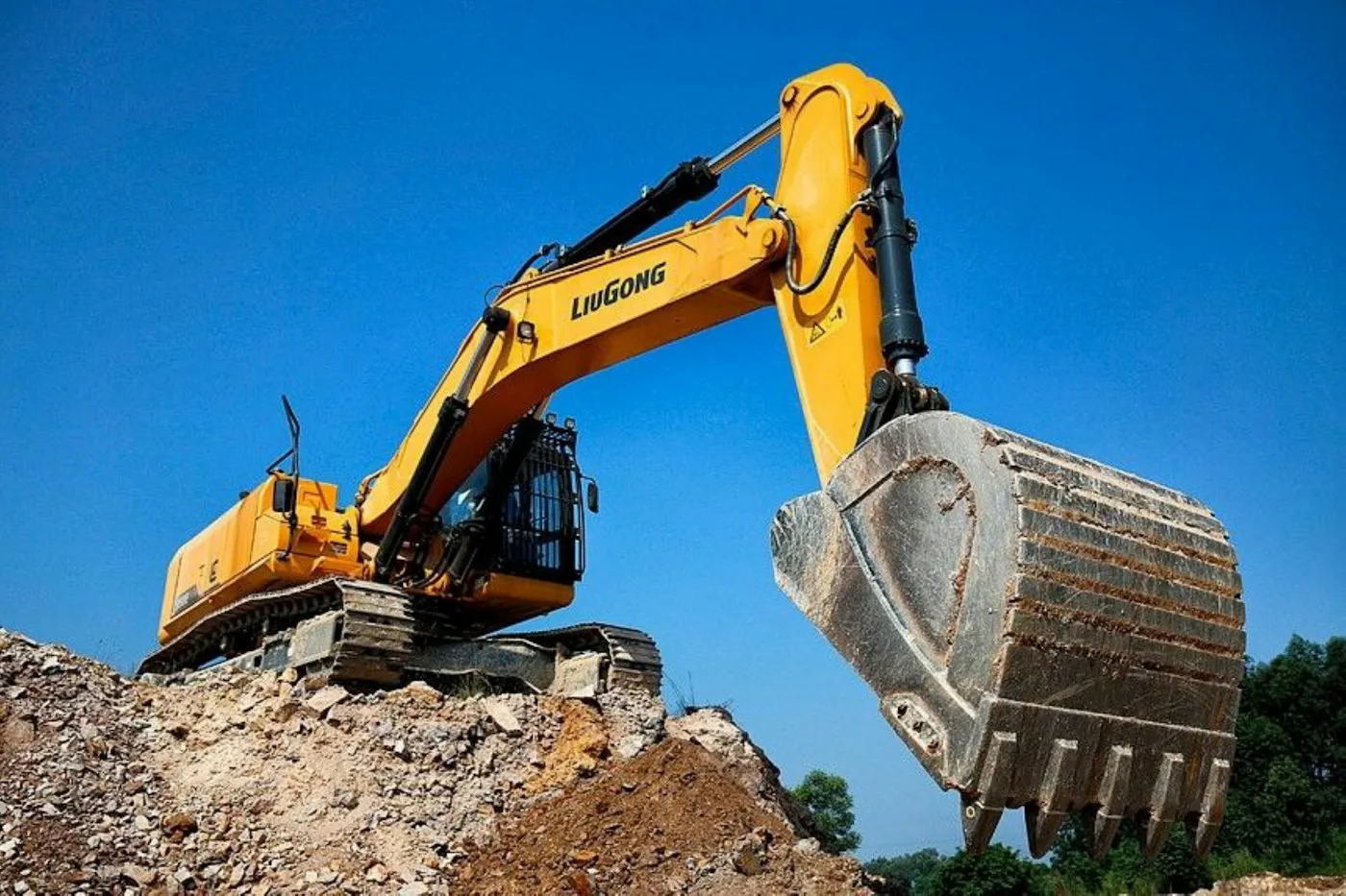 Excavator with a large bucket on rocky ground